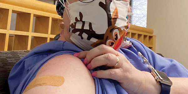 Nurse showing bandaid after coronavirus vaccine